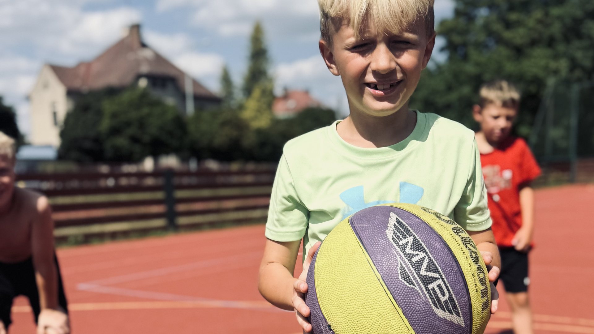 Chlapec s basketbalovým míčem na hřišti u ZŠ Spořilov